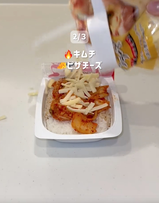 パックご飯の上にタレとキムチとチーズをのせる様子
