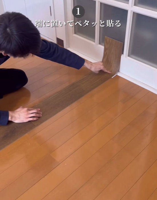 フロアマットを貼る男性