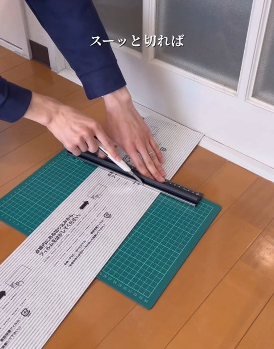 フロアマットをカットする男性