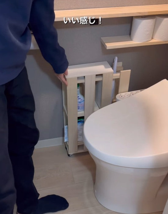 完成した収納棚をトイレに置く様子