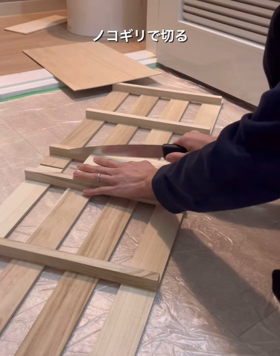 板材をのこぎりで切る様子