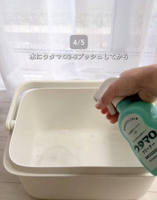 バケツに入れた水にウタマロクリーナーをプッシュする様子