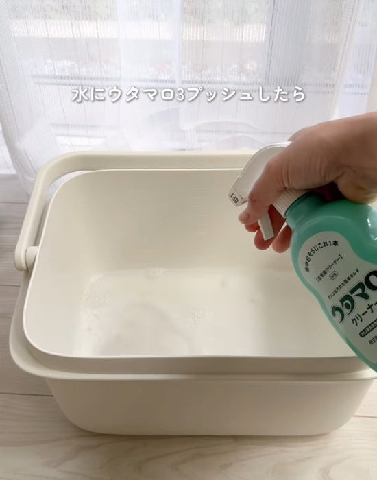 バケツに入った水にウタマロクリーナーをプッシュする様子