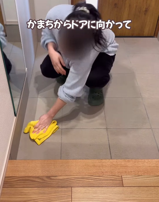 マイクロファイバーで玄関の掃除をする人