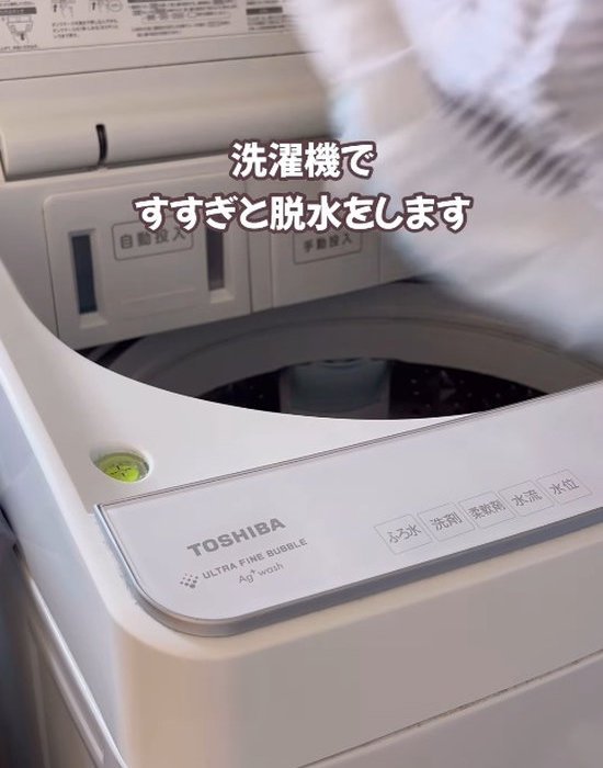洗濯機にカーテンを入れる様子