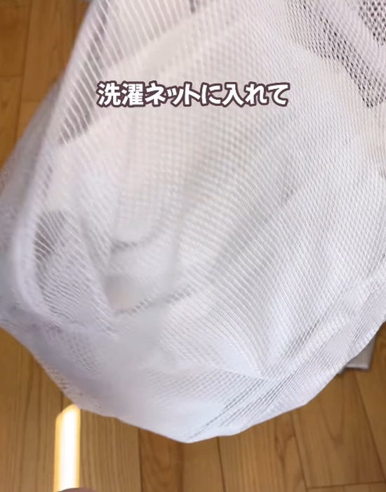 丸めたカーテンを洗濯ネットに入れる様子