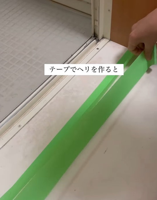 養生テープの上に養生テープを重ねて貼る様子