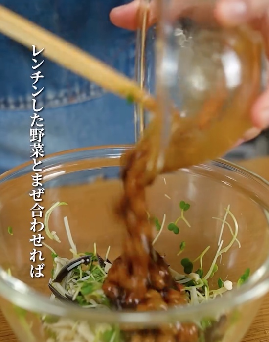 加熱したキクラゲとエノキとカイワレ大根に混ぜた調味料を入れる様子