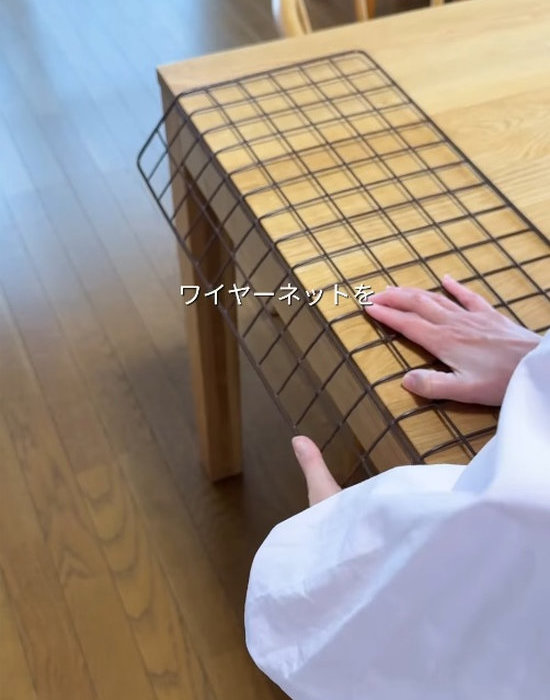 セリアのワイヤーラティスをテーブルの角で折り曲げている様子