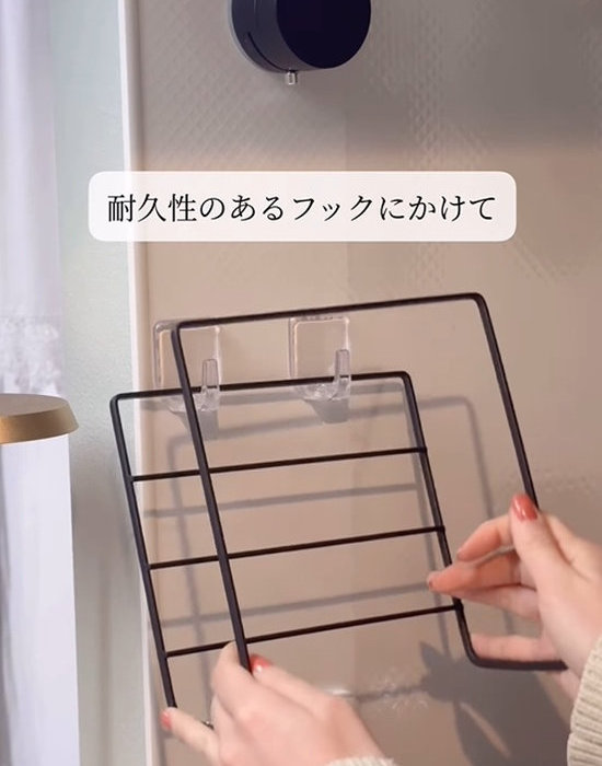 ディッシュラックをキッチンの壁に付けたフックにかける様子
