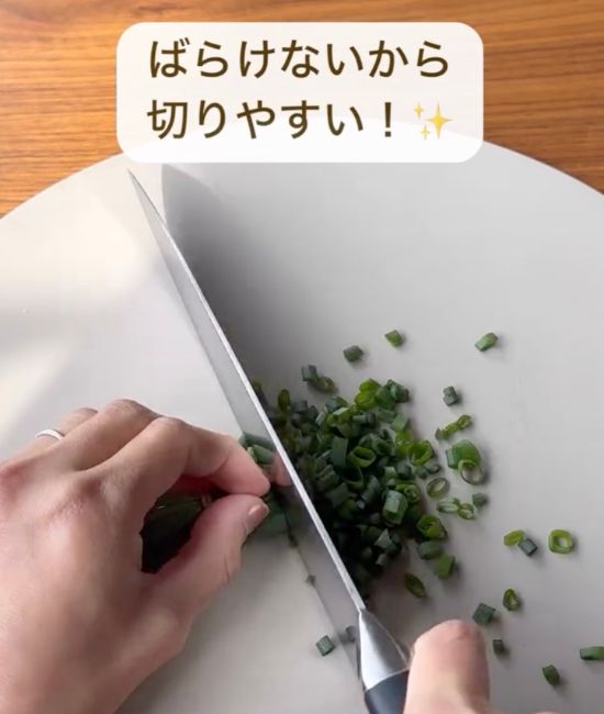 輪ゴムを付けた状態で青ネギを包丁で切る様子