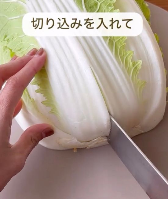 白菜の芯の部分に包丁で切り込みを入れる様子