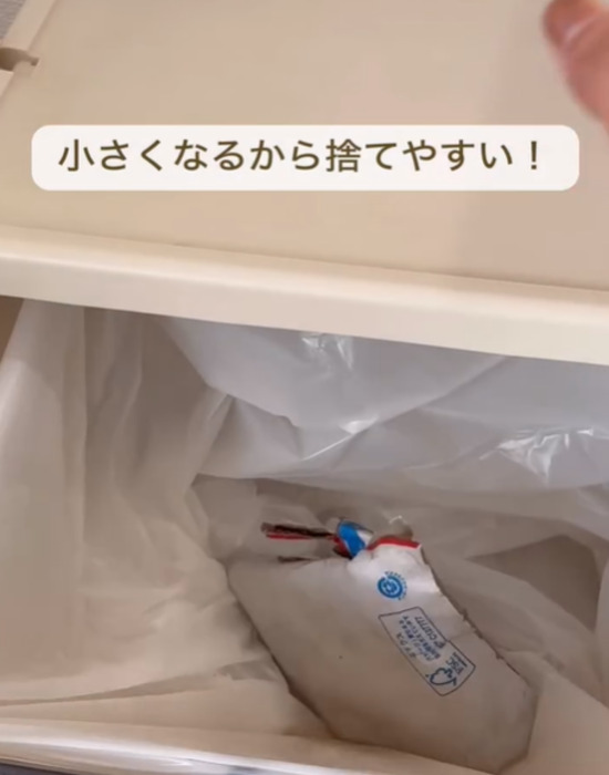 水で濡らして小さくたたんだ宅配ピザの箱をゴミ箱に捨てる様子