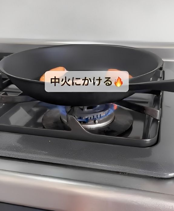 ウインナーと水を入れたフライパンを中火にかける様子