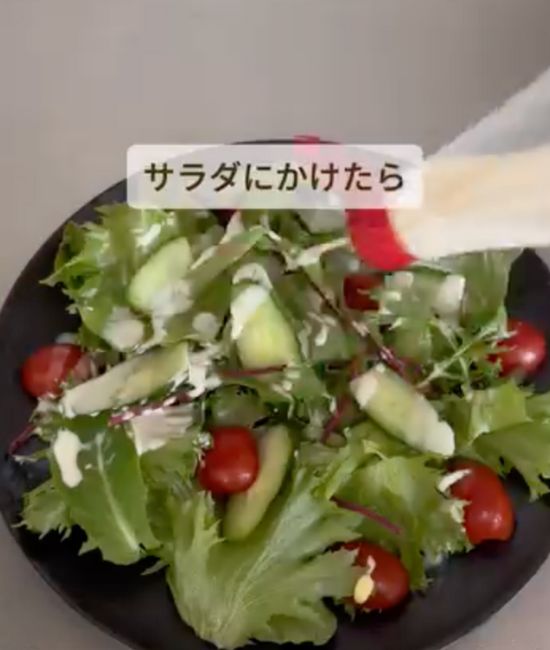 マヨネーズの容器で作ったドレッシングをサラダにかける様子