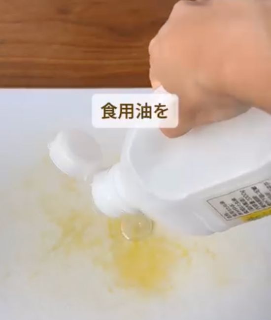 まな板の着色汚れが付いている箇所にサラダ油を垂らす様子