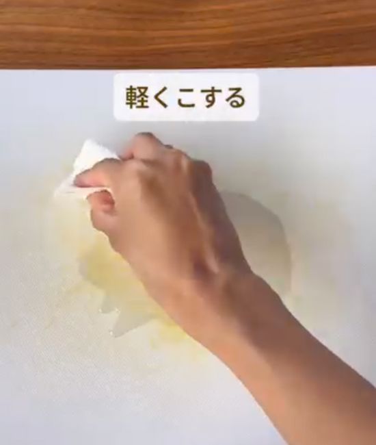 まな板の上に垂らしたサラダ油をキッチンペーパーで伸ばす様子