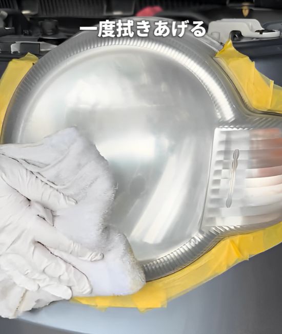 ヘッドライトの水分を柔らかい布で拭き取る様子