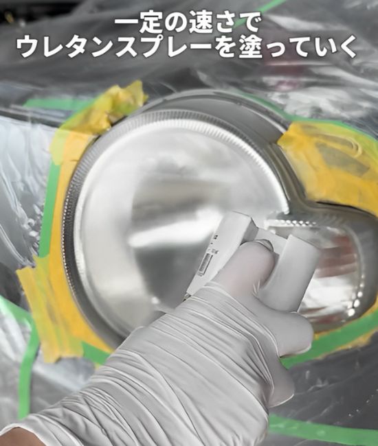 『２液型ウレタンスプレー（クリヤー）』をヘッドライトに吹きかける様子