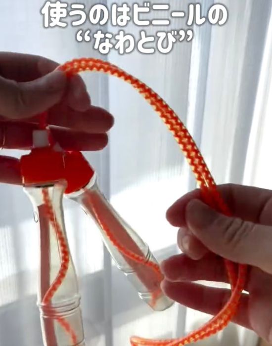 赤色のビニール縄跳びを手に持っている様子