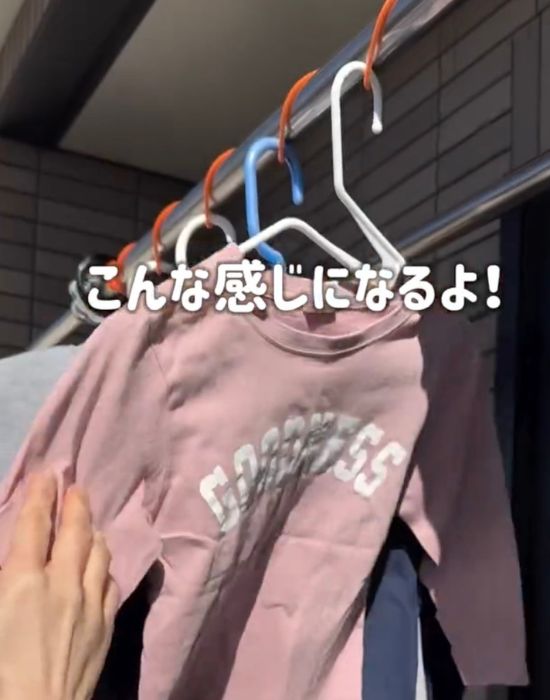 物干しざおに巻き付けたビニール縄跳びの隙間に洗濯物をかけたハンガーを通した様子