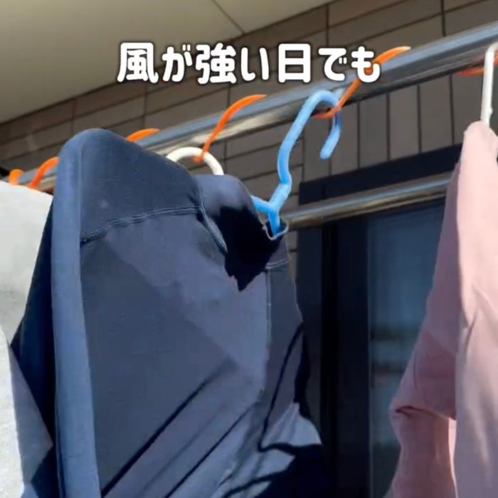 ハンガーにかけた洗濯物が風にあおられても物干しざおから落ちない様子
