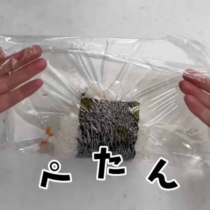 のりとご飯をのせたラップを半分に折りたたんだ様子