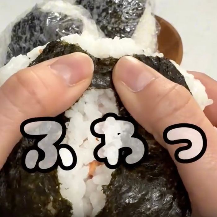 おにぎりを手で半分に割く様子