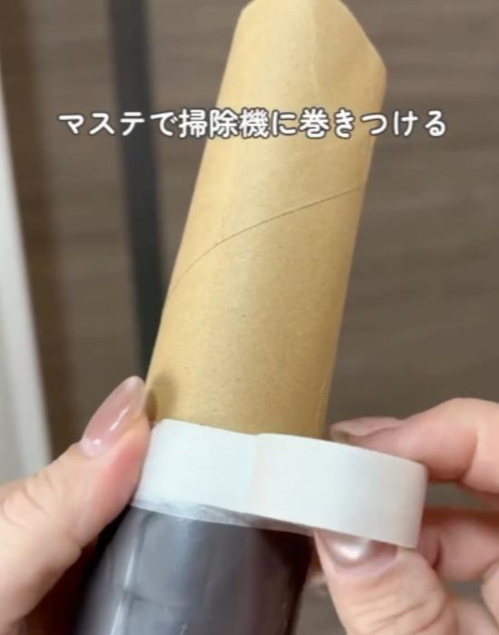 ノズルを外した掃除機の先にカットしたトイレットペーパーの芯をマスキングテープで貼り付ける様子