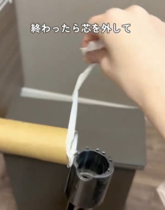 トイレットペーパーの芯を掃除機から取り外す様子