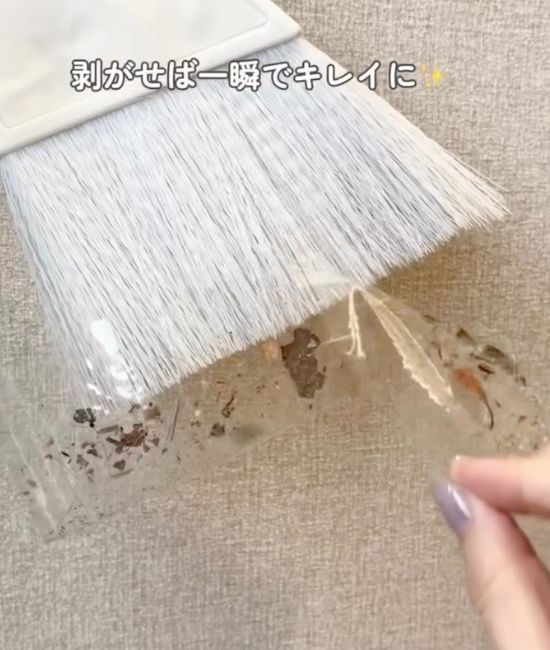 ゴミのついたOPPテープをほうきの穂先からはがす様子