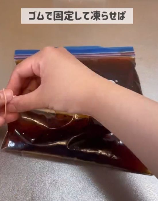 濃縮麦茶を入れたチャック付き保存袋を割り箸で挟んで両端を輪ゴムで固定する様子