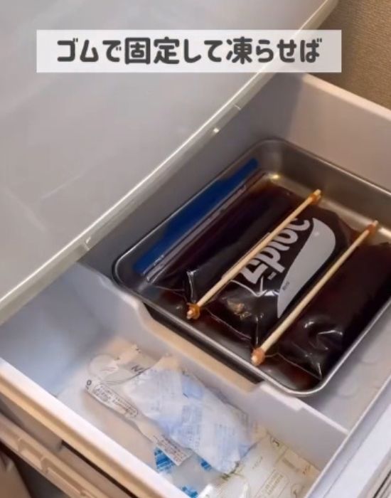 濃縮麦茶を入れたチャック付き保存袋を割り箸で固定した状態で冷凍庫に入れた様子