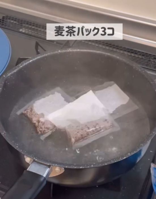 鍋で沸騰させたお湯に麦茶パックを３つ入れた様子