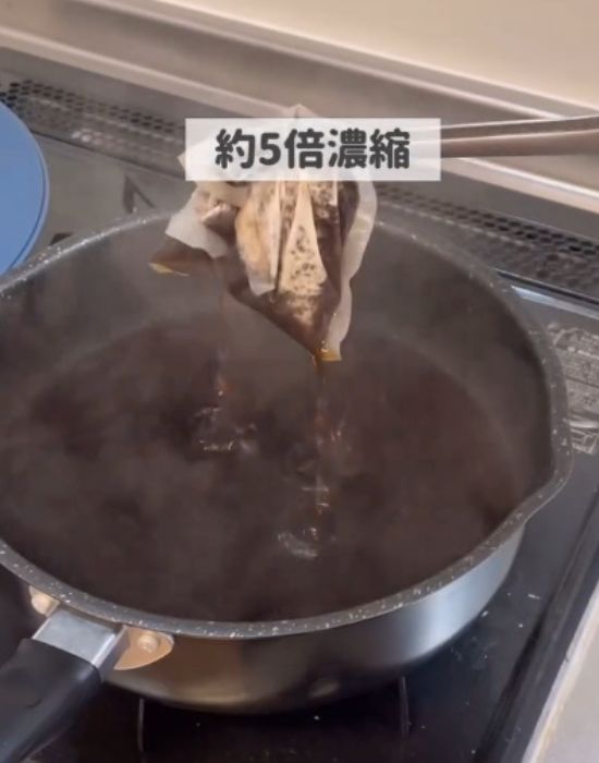 鍋に入れた麦茶パックを箸で取り出す様子