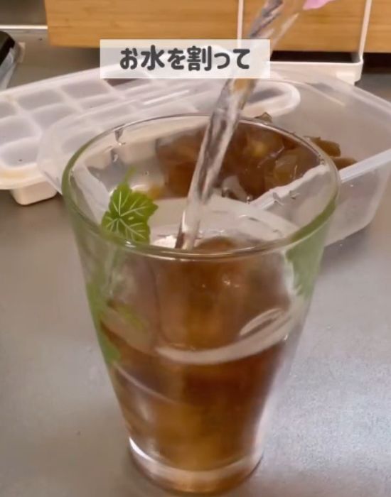 濃縮麦茶氷を入れたコップに水を入れる様子