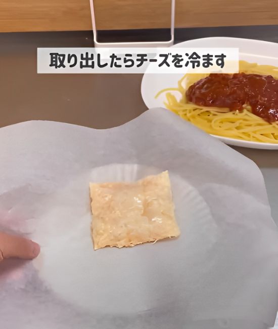 クッキングシートの上にのせて加熱したスライスチーズの写真