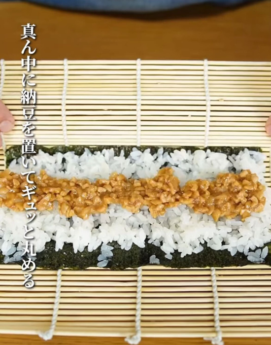 巻きすに焼き海苔と寿司めし、ガリ入り納豆をのせて丸める様子