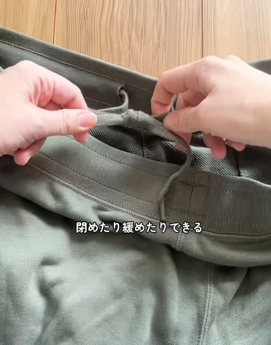 ズボンの紐を左右に引っ張る様子