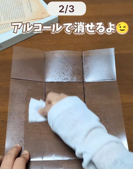 アルコールを含ませたティッシュペーパーでクリアファイルの線を消す様子