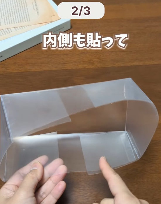重ねたクリアファイルの内側にテープを貼る様子