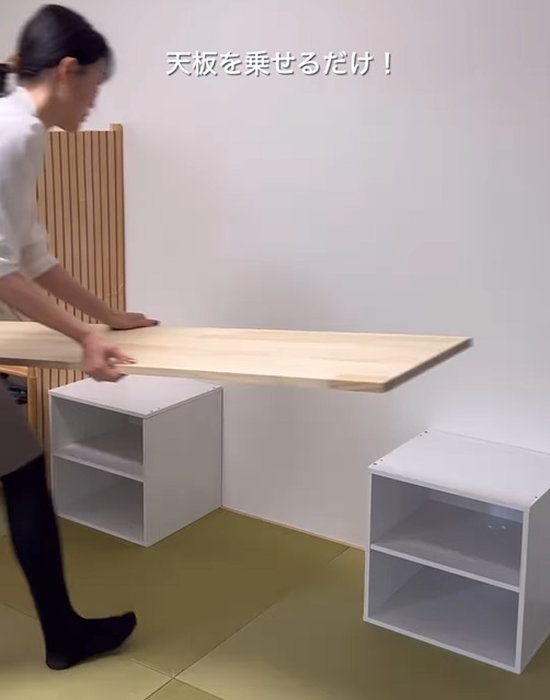 キューブボックスの上にラジアータパイン材をのせる様子