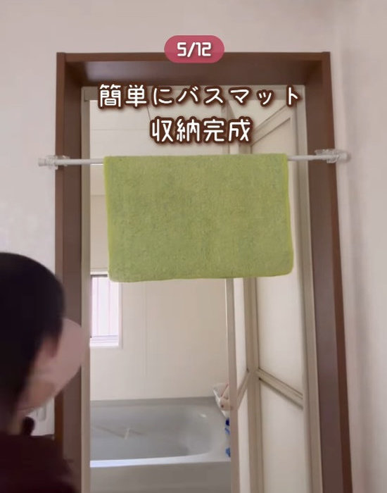 浴室のドアに取り付けたかもいフックと突っ張り棒にバスマットをかけている様子
