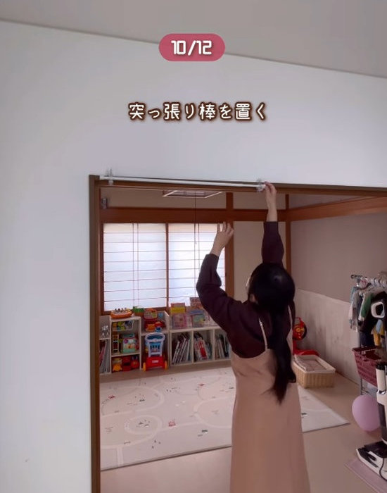 リビングのかもいにかもいフックを取り付けている様子