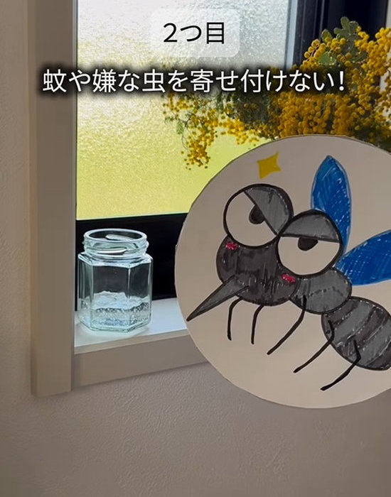 虫のイラストが描かれた紙と瓶を置いた窓辺