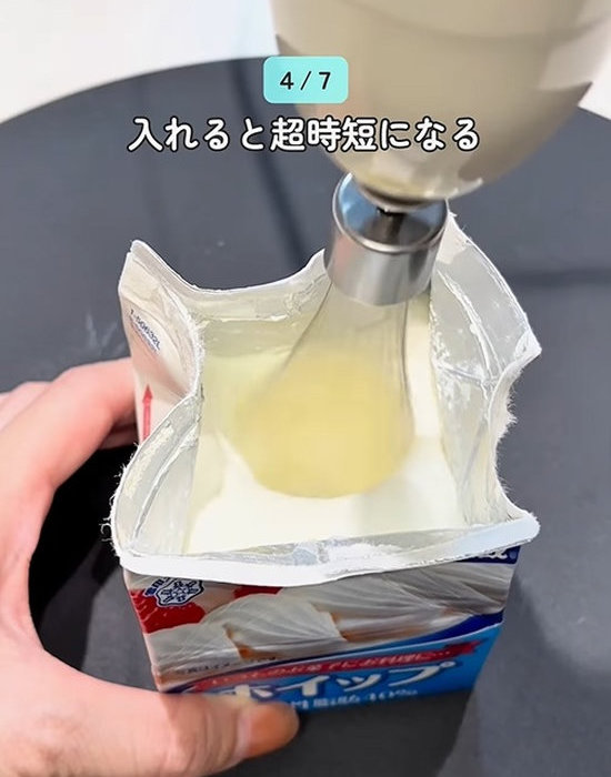 生クリームパックの中の生クリームを泡立て器で混ぜる様子