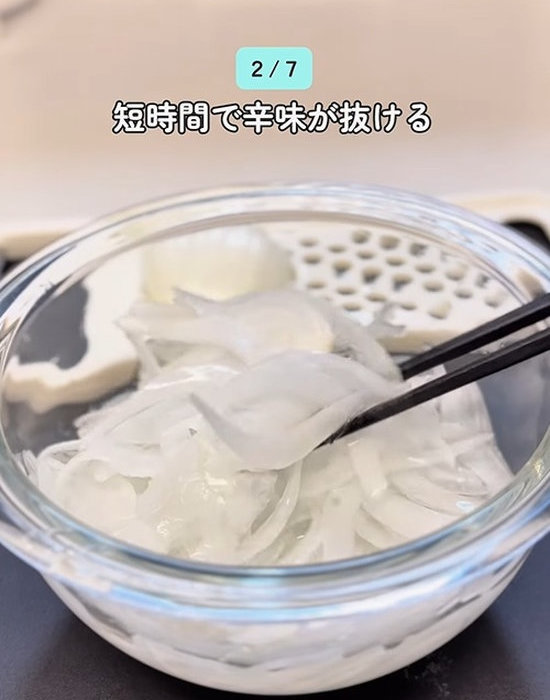 ボウルの水を切ったタマネギを箸で取る様子