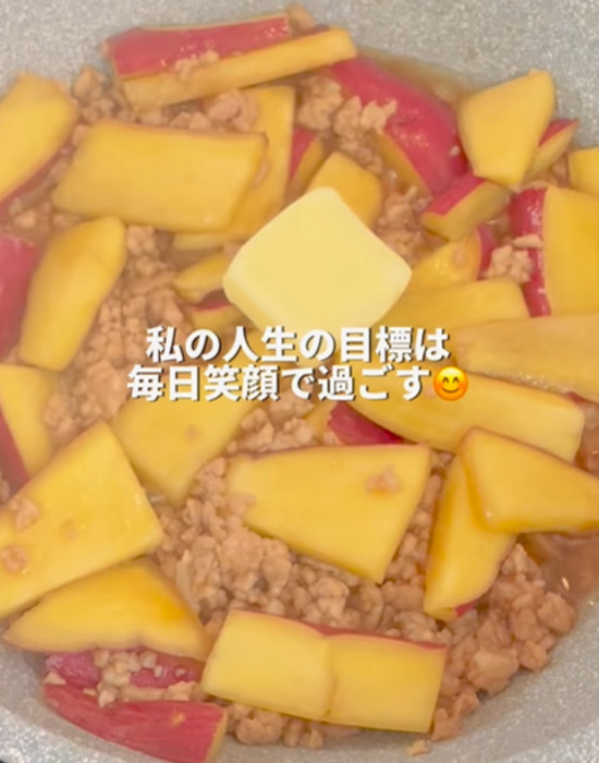 フライパンで炒めた豚ミンチとサツマイモにバターを加える様子