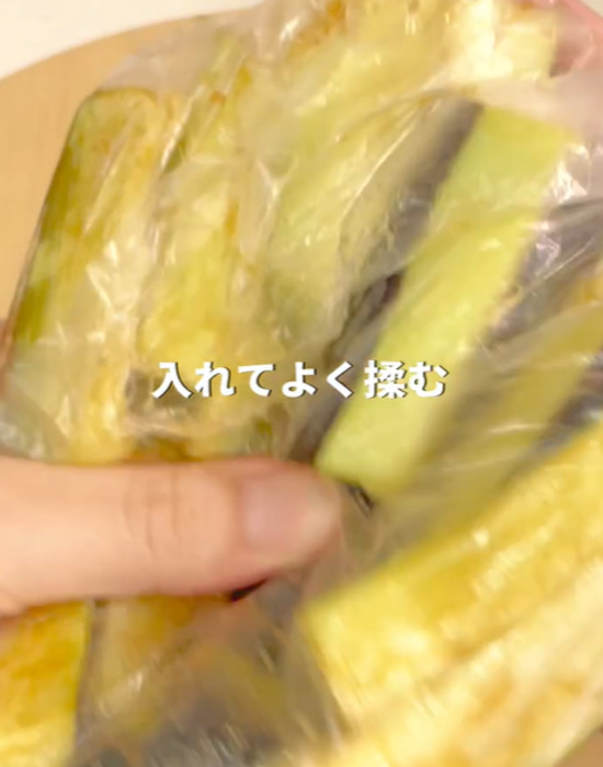 切ったナスをビニール袋に入れて調味料と混ぜる様子
