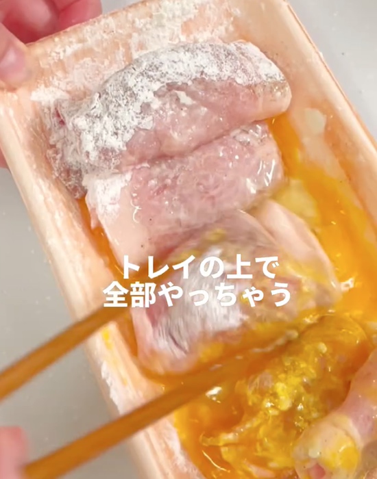 ハムを巻いた豚薄切り肉に薄力粉と卵をまぶす様子